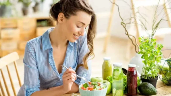 Woman eating fresh salad and detox juices for natural body and mind cleansing.